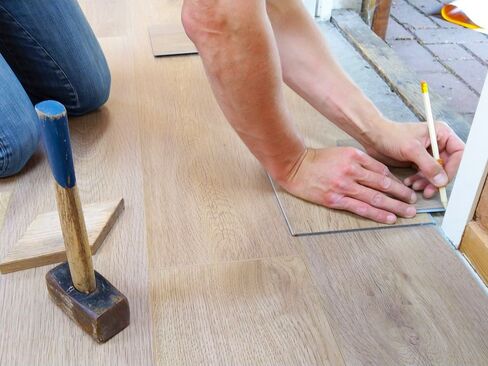 Worker installing engineered hardwood flooring